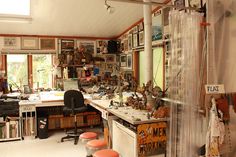 a room filled with lots of clutter and pictures on the wall next to a window