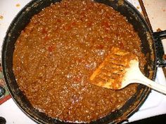 a skillet filled with food sitting on top of a stove next to utensils