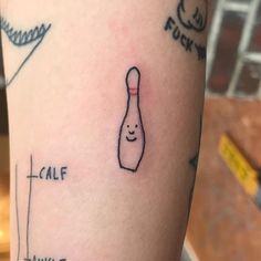 a person with a tattoo on their arm that has a bowling ball in the shape of a bowling pin