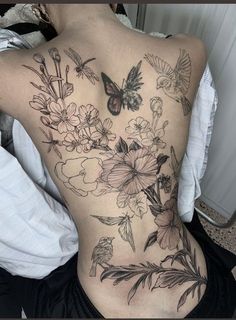 a woman's back with flowers and butterflies on it