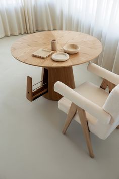 a wooden table with two chairs around it and plates on the plate rack next to it