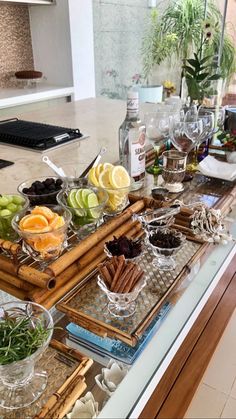 an assortment of fruits and vegetables on serving trays in front of a kitchen counter