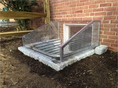 a metal gate that is next to a brick wall and some dirt on the ground