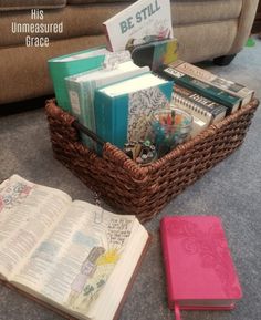 a basket filled with books next to an open book on top of a carpeted floor