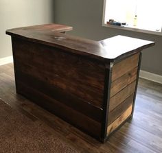 an empty room with a wooden desk in the middle and a window on the other side