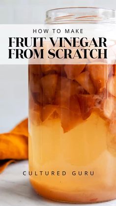 a glass jar filled with fruit vinegar from scratch on top of a white countertop