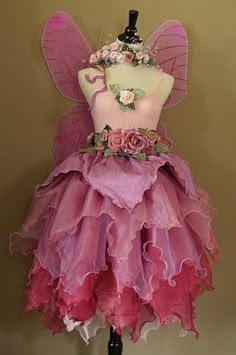 a pink and purple fairy dress on a mannequin headdress with flowers