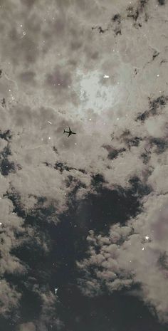 an airplane is flying through the cloudy sky