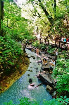 people are standing on wooden platforms over a river