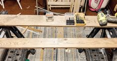 a wooden bench sitting on top of a floor next to other woodworking supplies and tools