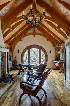 a living room filled with furniture and a chandelier hanging from the ceiling over a wooden floor