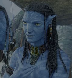 a man with blue skin and braids standing next to another man in avatar makeup