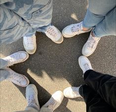 four people standing in a circle with their feet on the ground