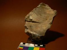 a piece of rock sitting on top of a wooden table next to a color block