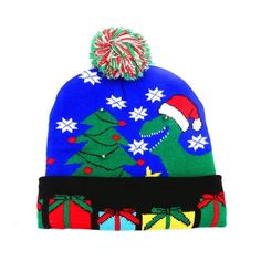 a blue hat with christmas trees on it and a pom - pom in the middle