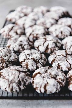 chocolate crinkle cookies on a cooling rack with powdered sugar sprinkled on top