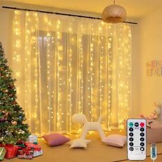 a living room decorated for christmas with lights on the curtains and presents under the tree