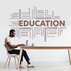 a man sitting at a desk with a laptop in front of him and the word education written on it