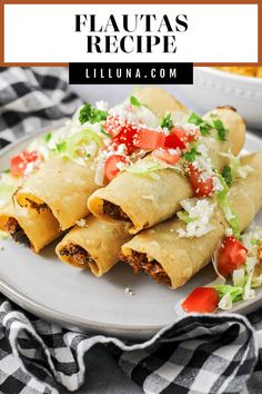 a white plate topped with burritos covered in lettuce and tomatoes