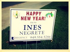 a happy new year from ines negrete sign sitting on the grass next to a sidewalk