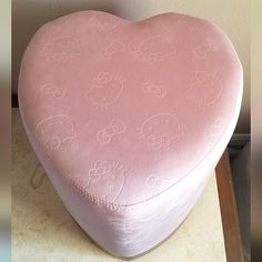 a pink heart shaped cushion sitting on top of a table