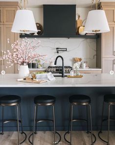 three stools sit at the center of a kitchen island