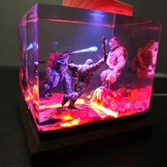 an aquarium with godzillas in it on a table next to a person holding a knife