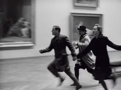 black and white photograph of three people running