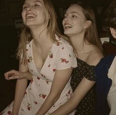 two young women are laughing together in the dark