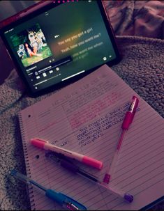 a notebook, pen and laptop computer sitting on top of a carpeted floor next to each other