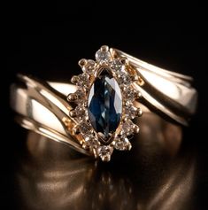 a close up of a ring with a blue stone in it on a black surface