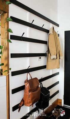 there is a coat rack on the wall with shoes and backpacks hanging from it