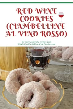 a bowl filled with donuts sitting on top of a table next to a glass of wine