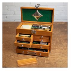 an open wooden box with several drawers and compartments in it on top of a table