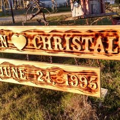 two wooden signs with names on them in the grass