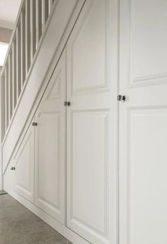 an empty room with white cupboards and stairs