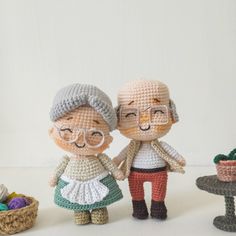 two crocheted dolls standing next to each other