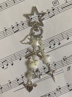 a christmas tree charm sitting on top of sheet music with musical notes in the background