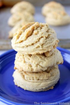 three cookies stacked on top of each other on a blue plate with cookie tins in the background