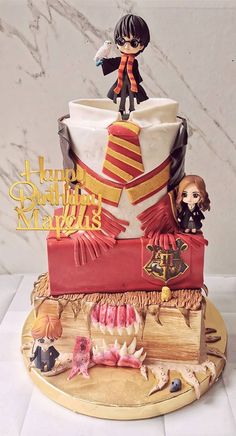 a birthday cake with harry potter figurines on top