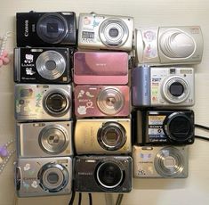 there are many different types of cameras on the wall together, and one has a camera attached to it