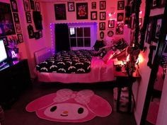 a bedroom decorated in pink and black with hello kitty rugs on the floor next to the bed