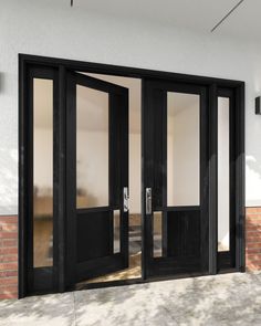 an open black double door on a brick building with glass panels and sidelightes