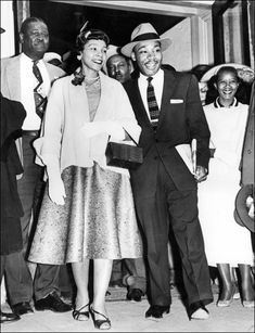 black and white photograph of man and woman holding hands in front of group of people