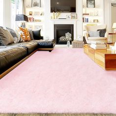 a living room filled with furniture and a pink rug