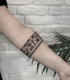 a person's arm with a flower tattoo on the left side of their arm