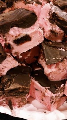 a pile of chocolate and pink desserts on top of a white paper plate,