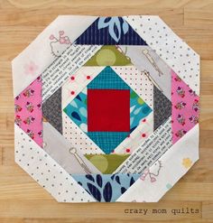 a colorful patchwork piece on top of a wooden floor with the words crazy mom quilts written across it