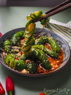 a bowl filled with green vegetables and chopsticks sticking out of the top of it