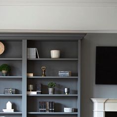 a living room filled with furniture and a flat screen tv on top of a book shelf